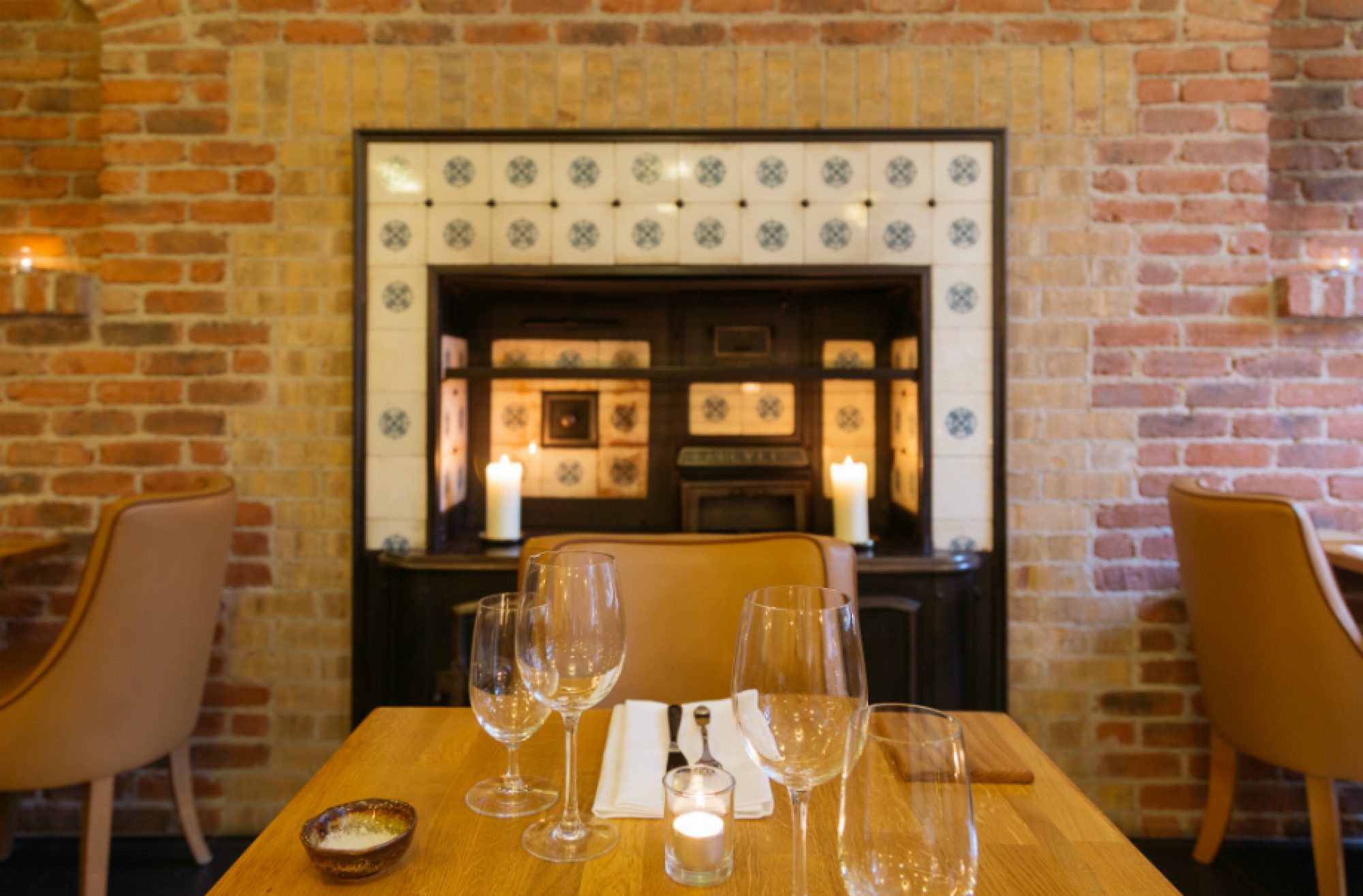 A set dining table beside the brick fireplace at Mr Fox, Dublin