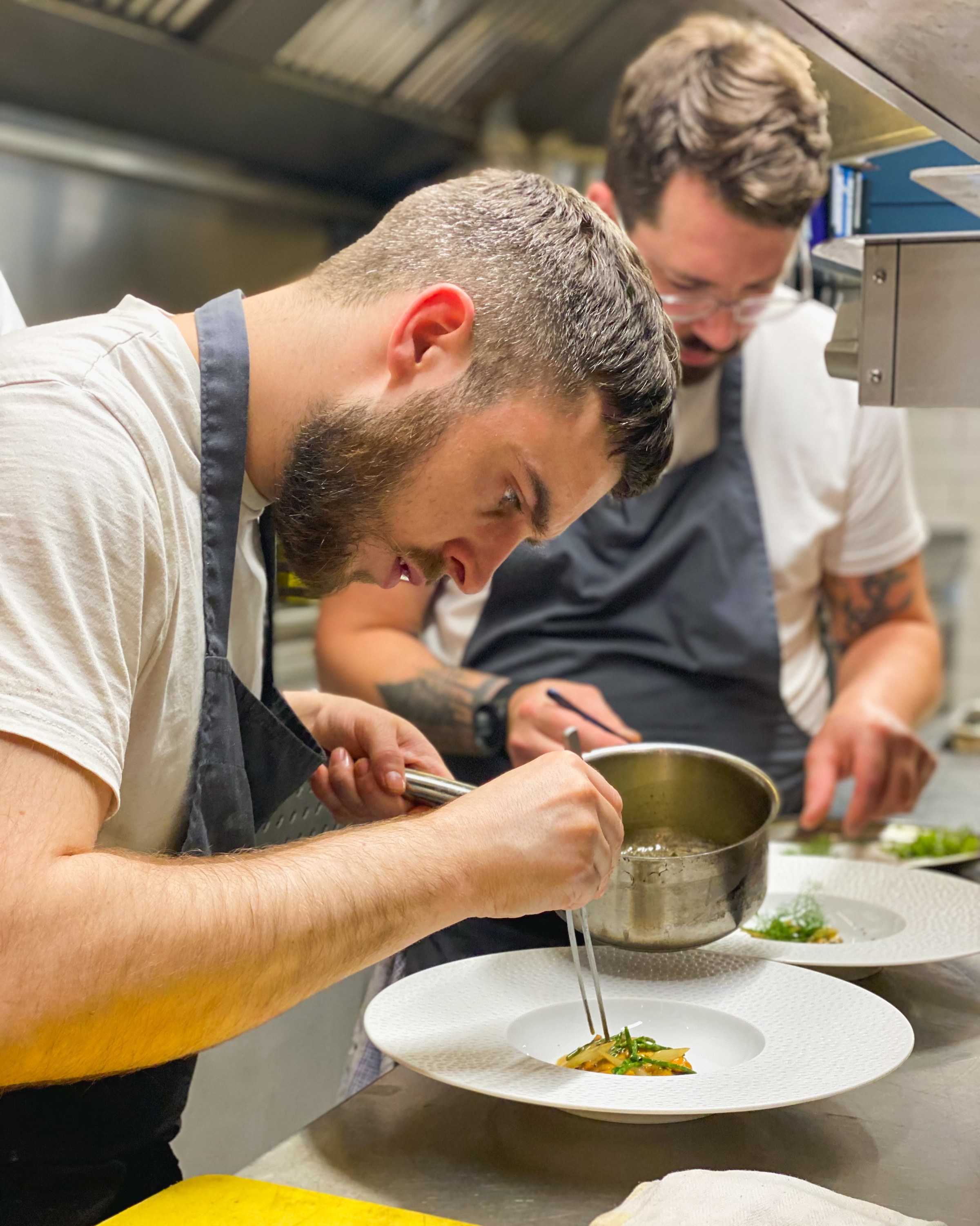 Chefs plating a dish in the kitchen at Delahunt, Dublin