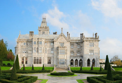 Adare Manor illuminated at dusk from the estate lawn