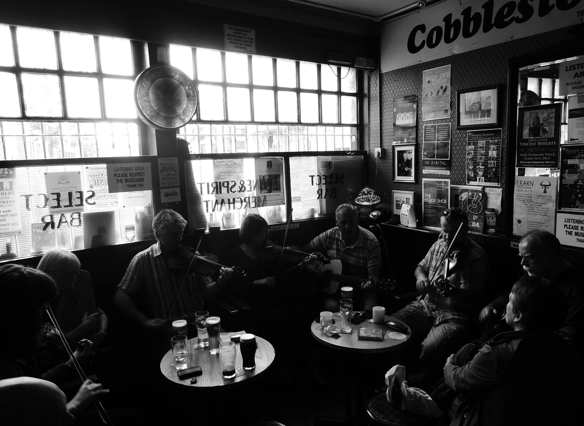 A traditional music session around the front tables at The Cobblestone