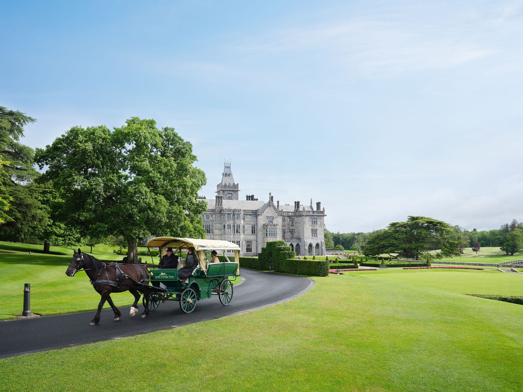 A horse-drawn carriage on the drive in front of Adare Manor