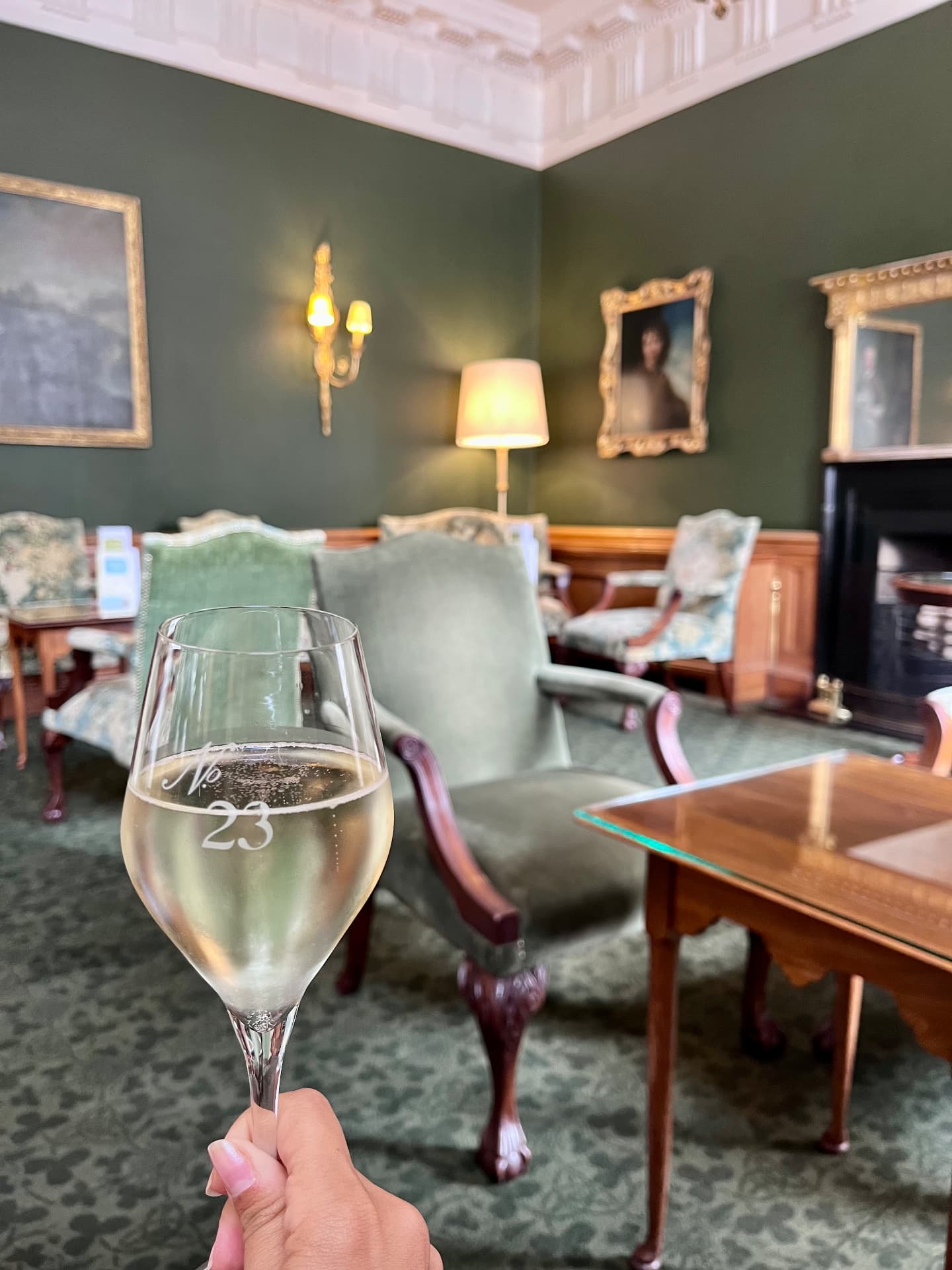 A drink in No. 23 at The Merrion, with green walls, portraits and Georgian chairs