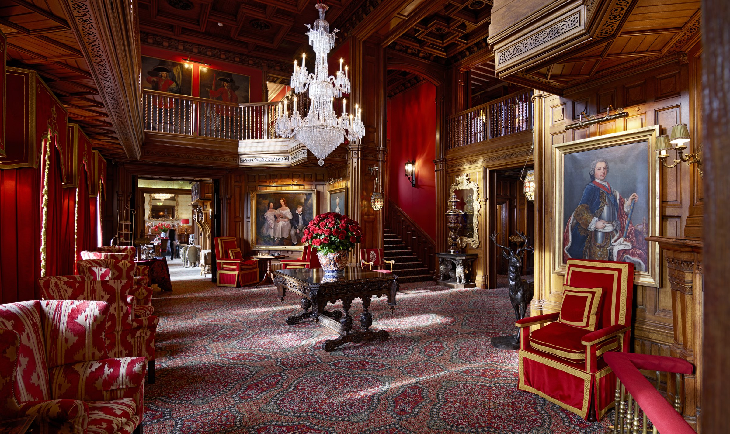The Oak Hall at Ashford Castle with panelling, portraits and a chandelier