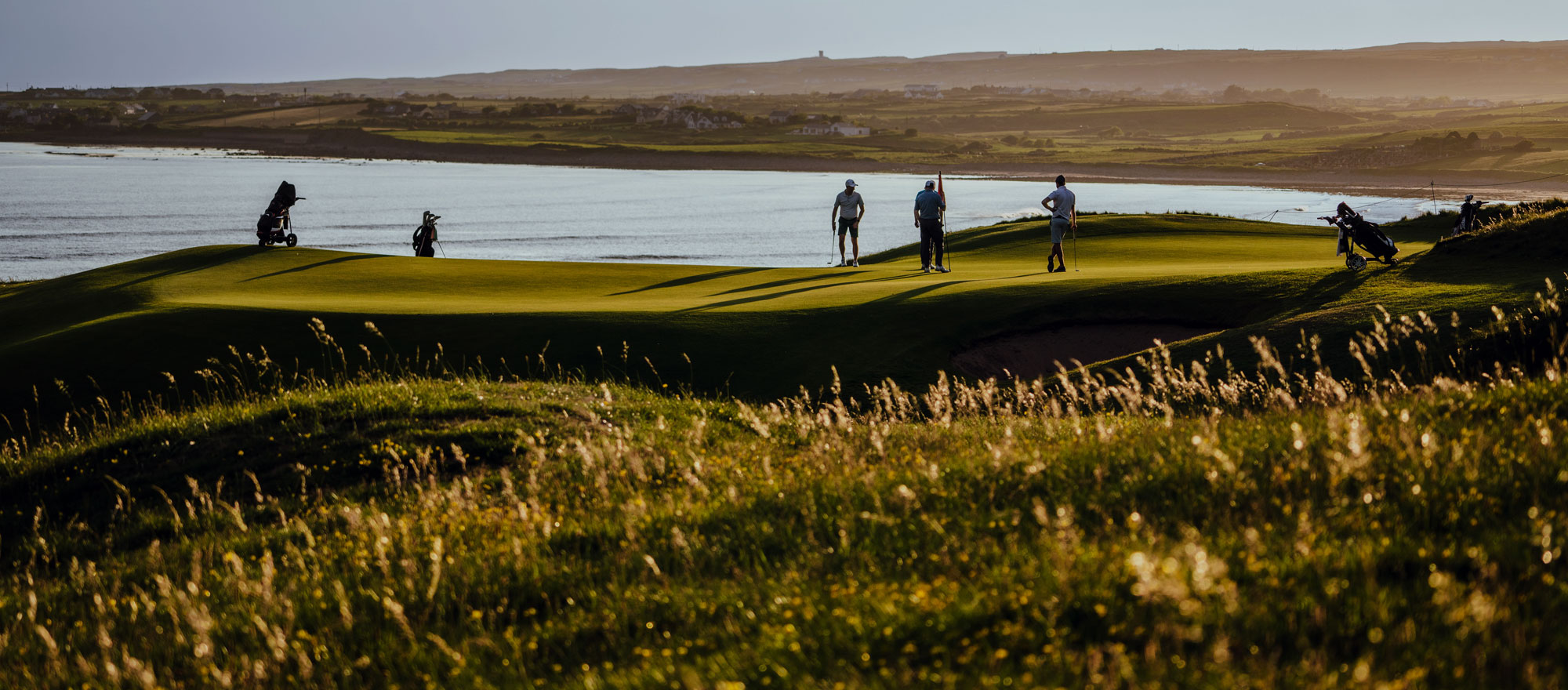 Aerial view of Lahinch Golf Club's Old Course rolling into the village and the Atlantic beach of Liscannor Bay in County Clare.