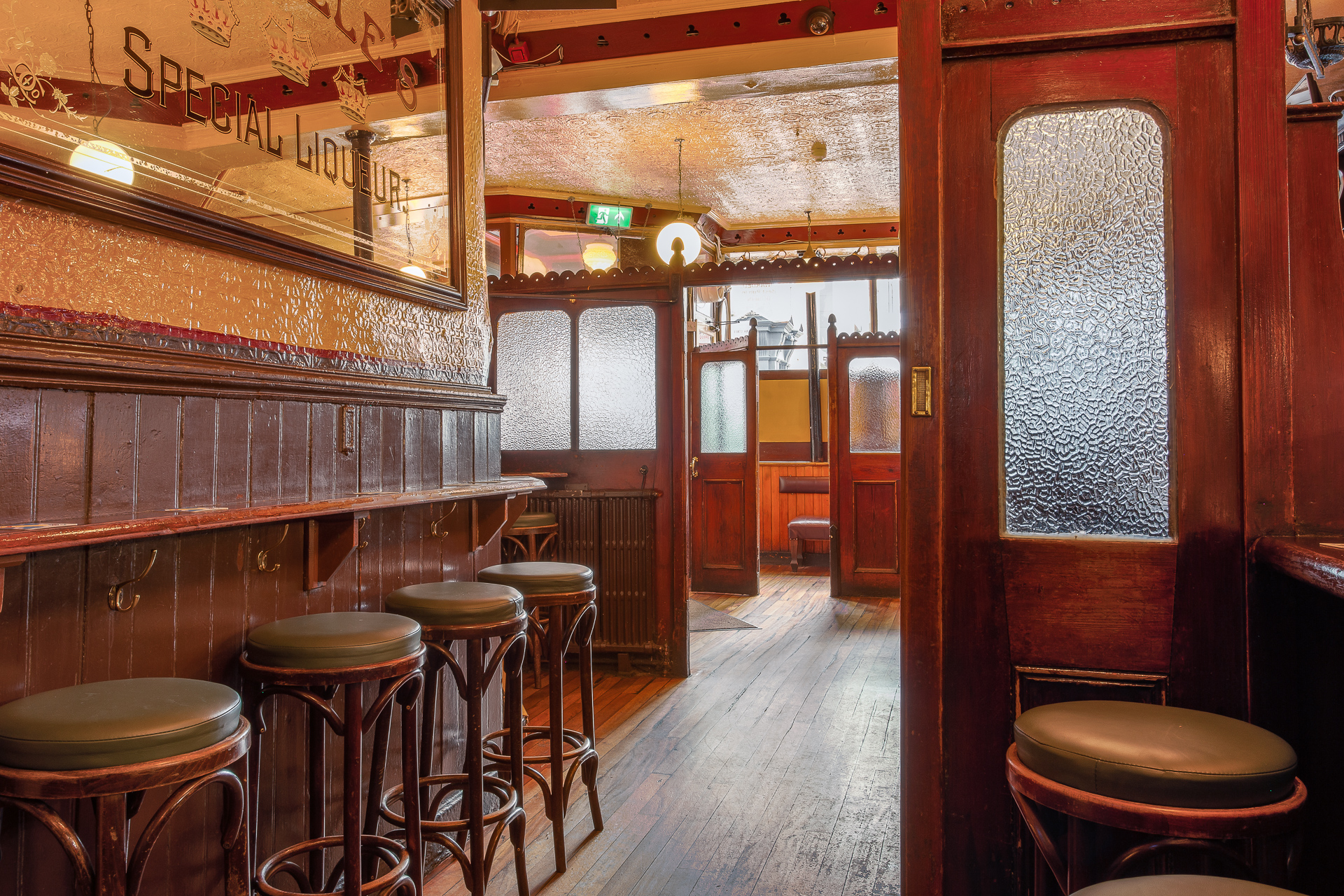 The Victorian snug at Kehoe's with mahogany panelling, bar stools and frosted glass doors