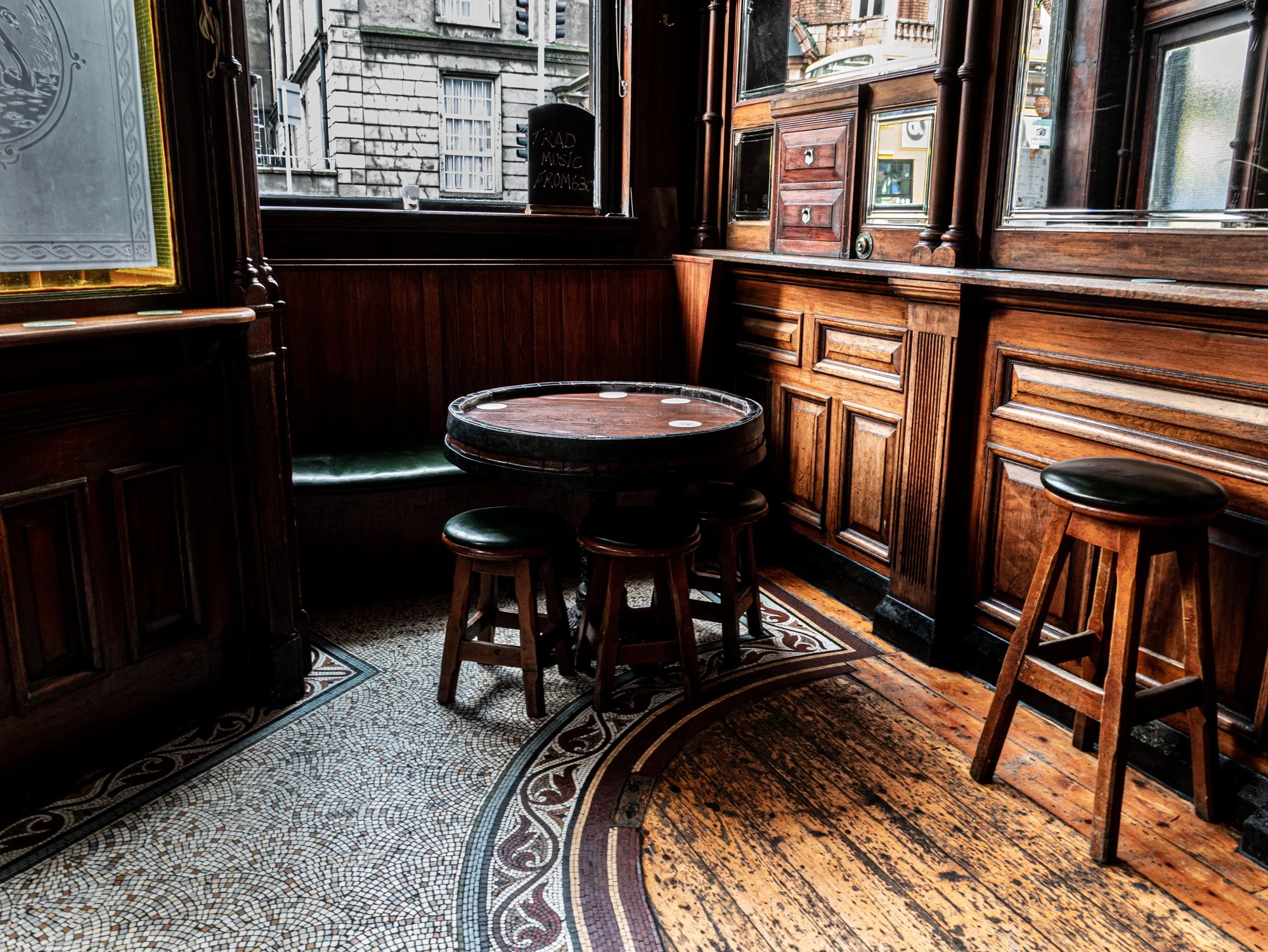 The corner snug with a barrel table and mosaic floor at The Swan