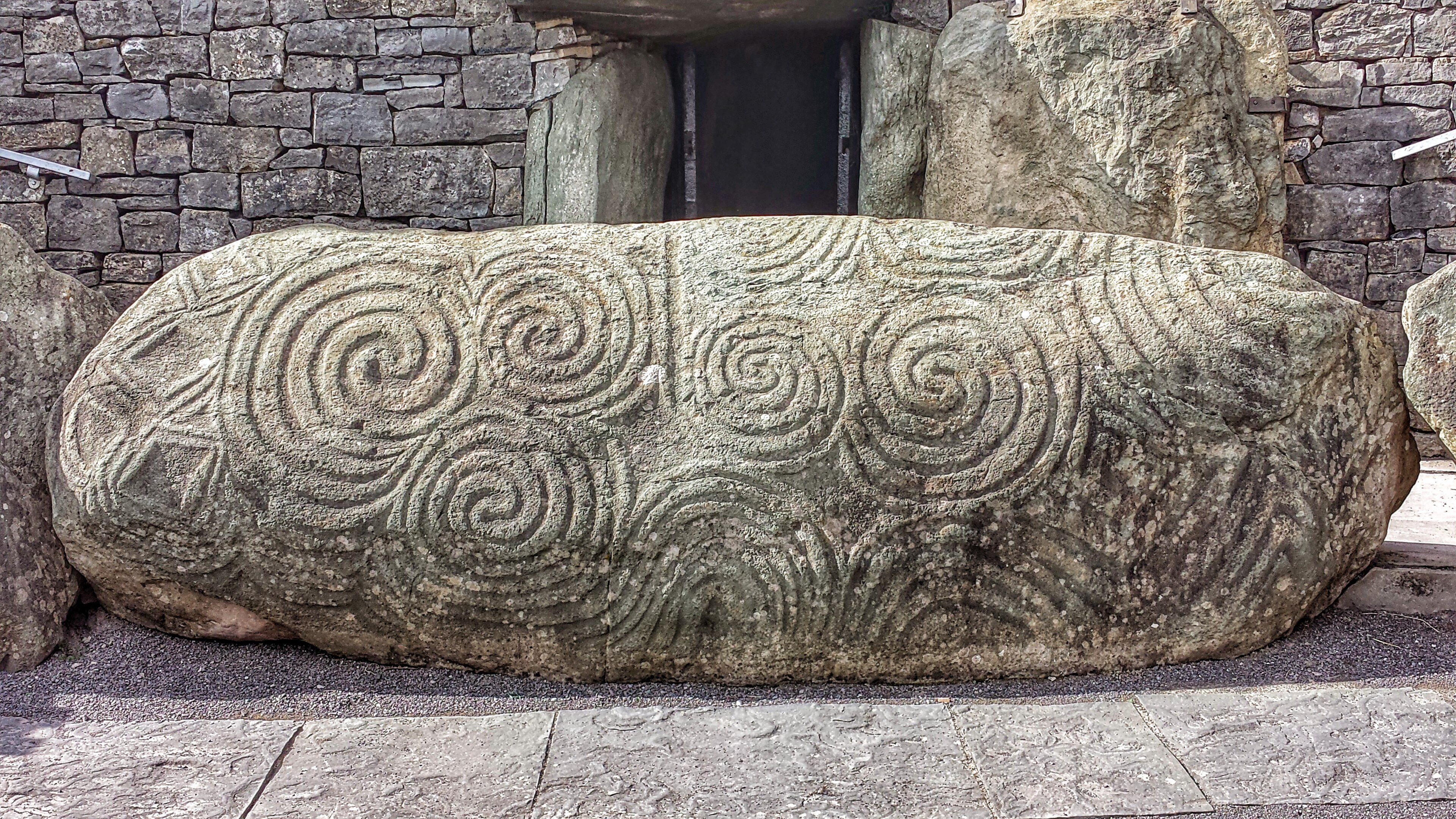 The carved triple spiral entrance stone at the doorway of the Newgrange passage tomb