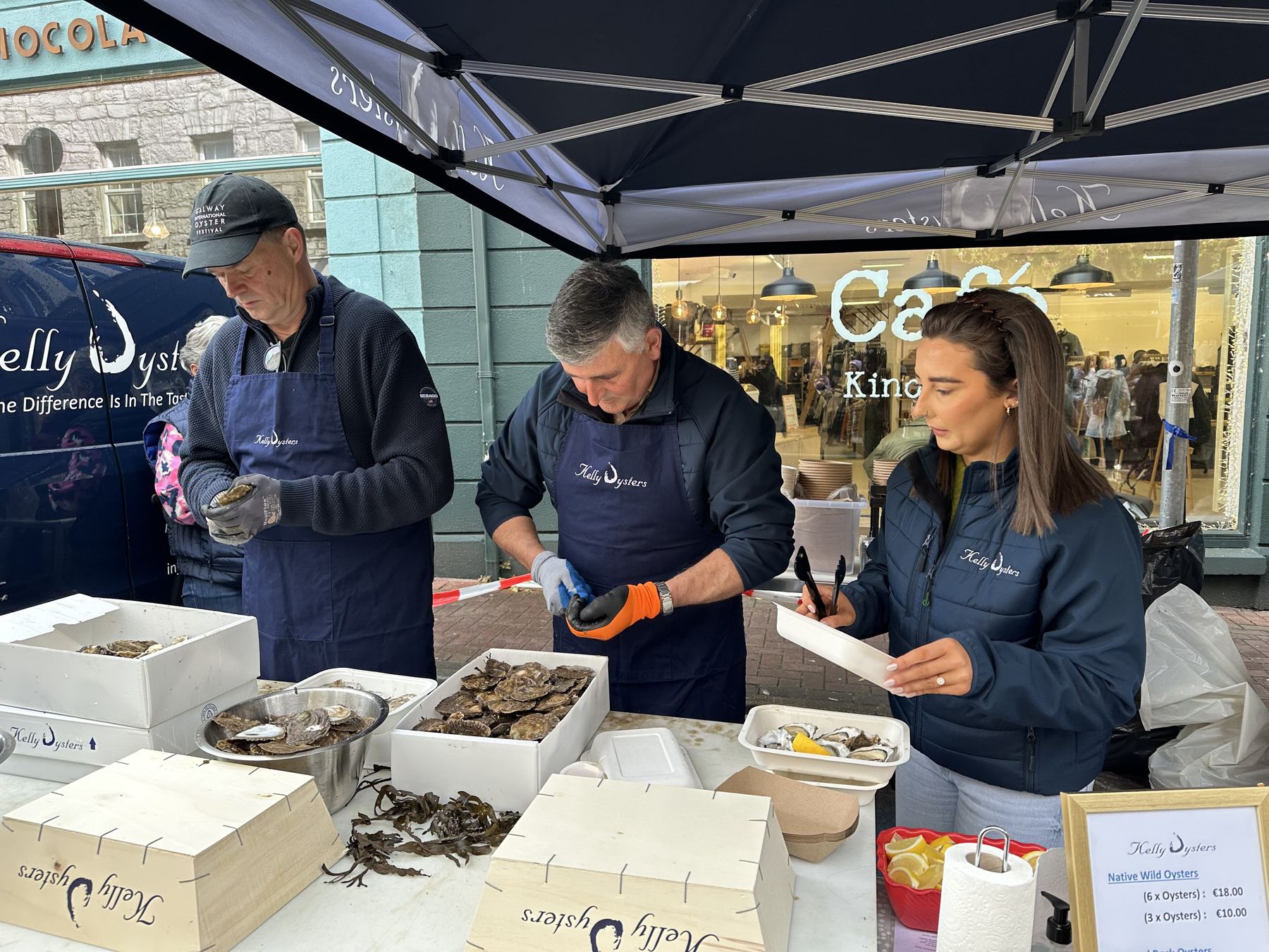 Native Galway oysters being opened at a market stall