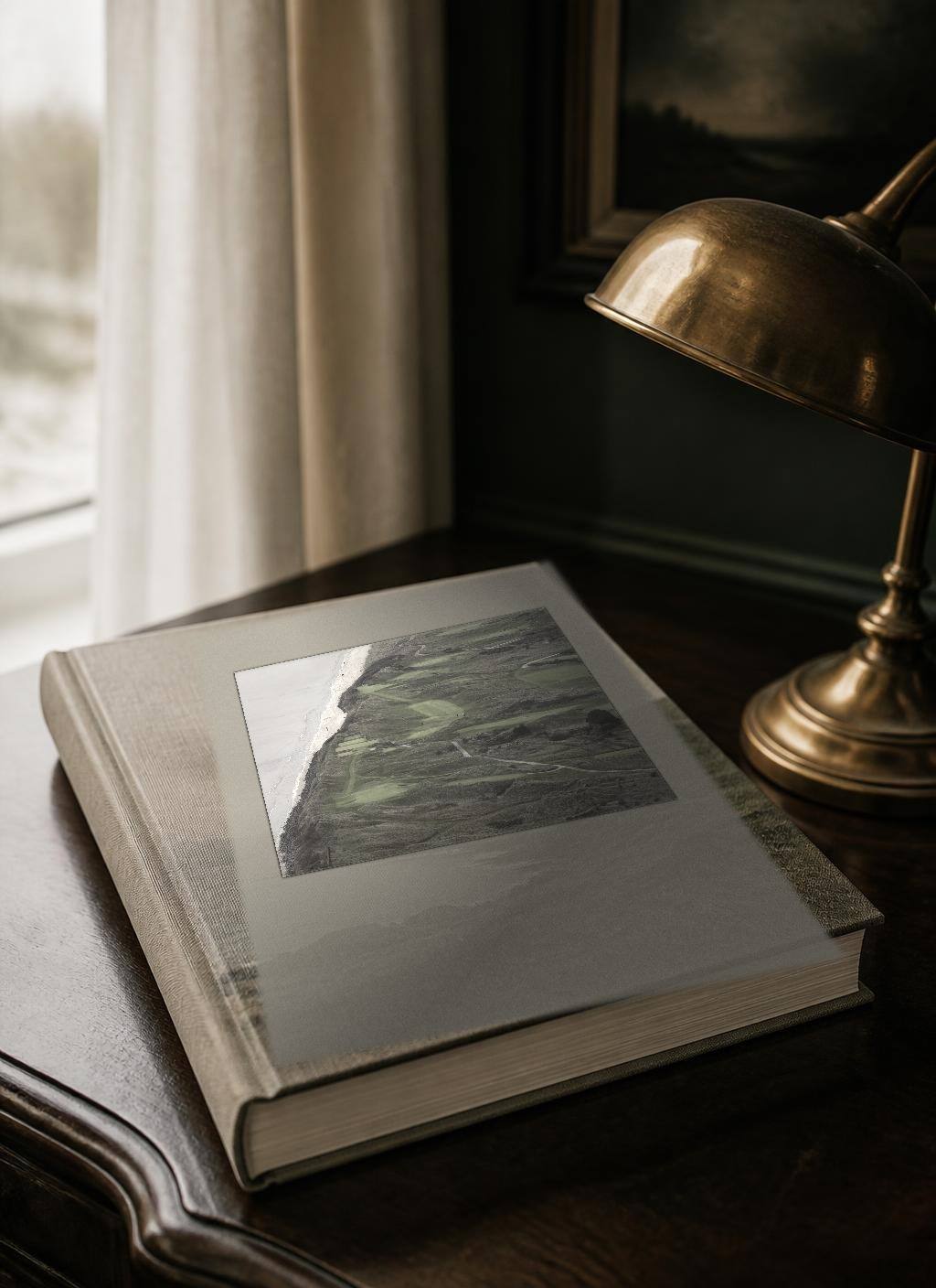 Cover of the bound printed edition N° 05, The Ireland Golf Itinerary, cover line “Greens & Gorse”, from The Ireland Edit. The linen-bound volume photographed as a physical book, with a documentary photograph of Portmarnock, County Dublin tipped into the front board.
